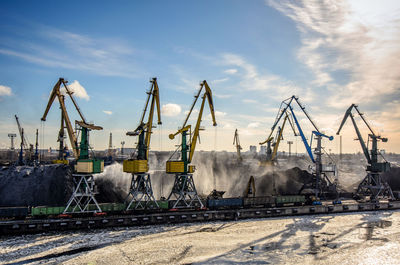 Cranes at construction site against sky