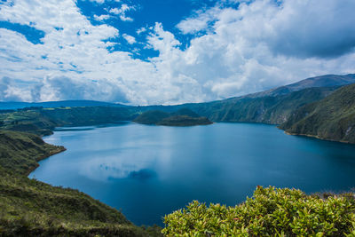 Scenic view of lake and mountains against blue sky