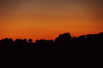 Scenic view of silhouette landscape against orange sky