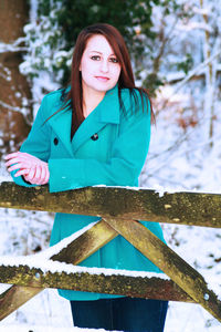 Portrait of smiling woman standing in snow