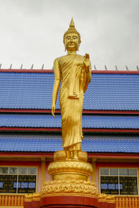 Low angle view of statue against temple building against sky