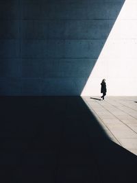 Side view full length of woman against wall on street