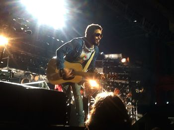 Man playing guitar at illuminated music concert
