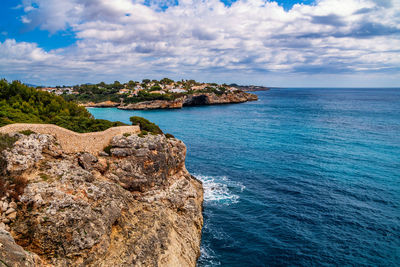 Scenic view of rocks in sea against sky