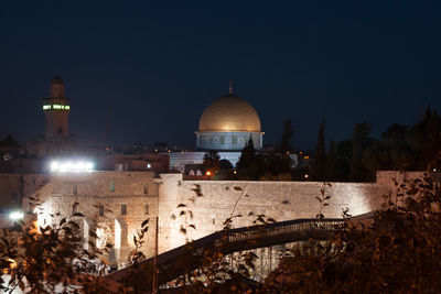 Illuminated building against clear sky at night