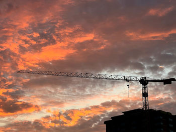 Low angle view of  construction crane against sky during sunset