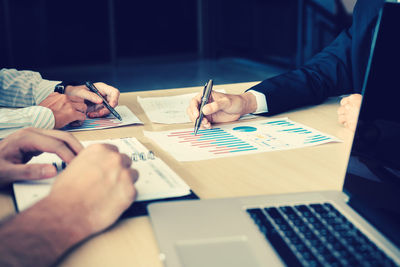 Cropped image of businessmen working at desk