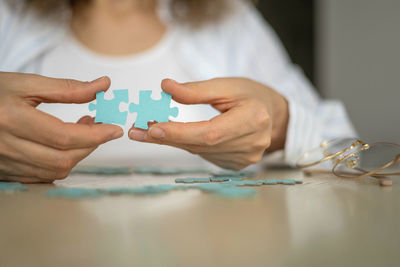 Cropped hand of woman holding jigsaw puzzle