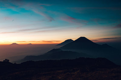 Scenic view of silhouette mountains against sky during sunset