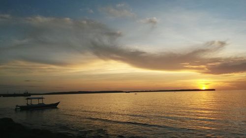 Silhouette boat sailing in sea against sky during sunset