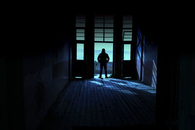 Rear view of man walking in corridor of building