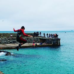 People on sea against sky