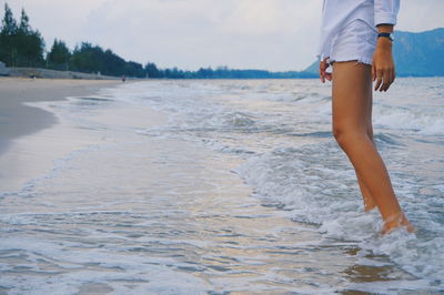 Low section of woman standing on beach