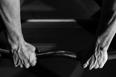 Cropped image of man gripping horizontal bar