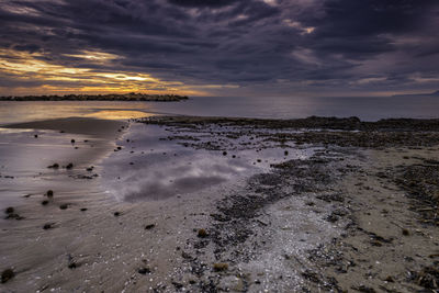 Scenic view of beach against sky during sunset