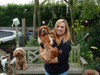 Portrait of woman with dogs standing in backyard
