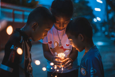 High angle view of children holding illuminated lighting equipment