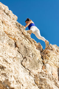 Low angle view of man standing on rock