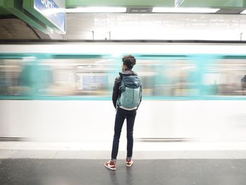 Rear view of man standing at railroad station