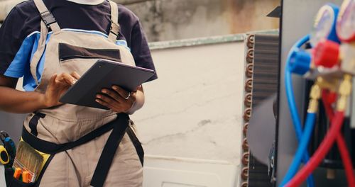 Midsection of man using digital tablet