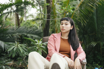 Portrait of young woman sitting outdoors