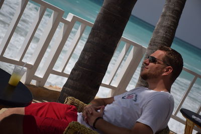 Man sitting by sea at beach