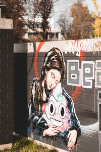 Portrait of young woman against brick wall