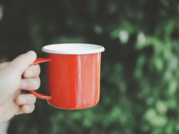 Close-up of hand holding coffee cup