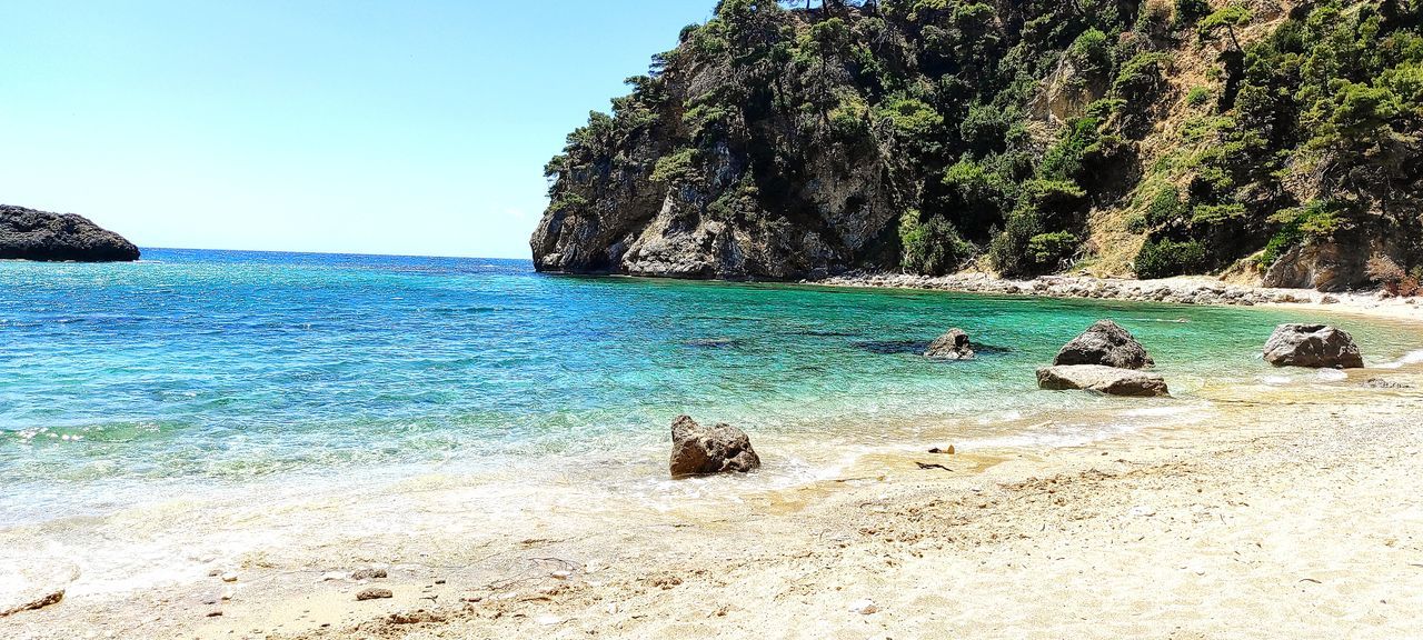 VIEW OF ROCKS ON BEACH AGAINST CLEAR SKY