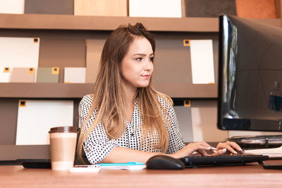 Portrait of young woman using laptop at home