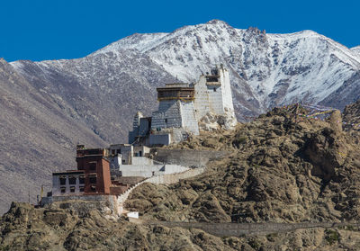 Castle against snowcapped mountains