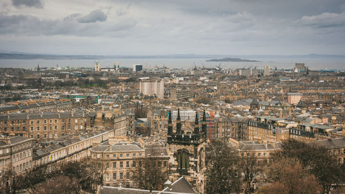 Aerial view of cityscape by sea against sky