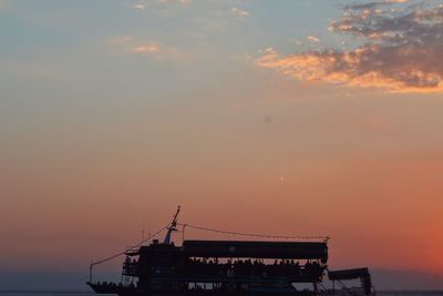 Silhouette boat in sea against sky during sunset