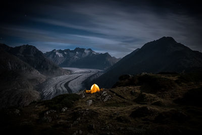 Scenic view of landscape and mountains against sky at night