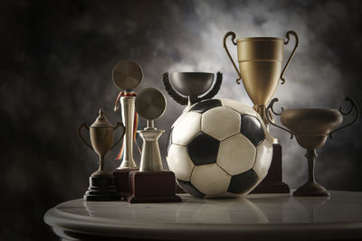 Close-up of trophies on table against black background