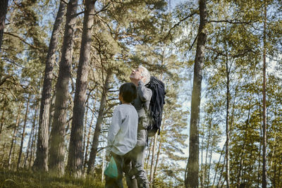 Rear view of man and woman standing in forest