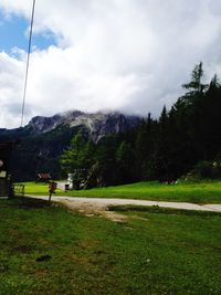 Scenic view of green landscape and mountains against sky