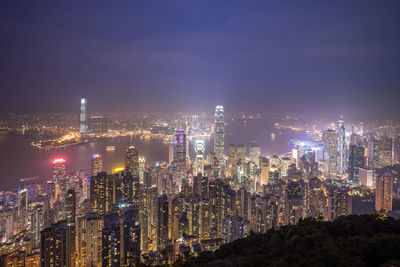 Illuminated cityscape against sky at night