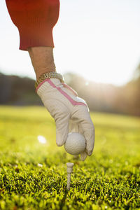 Woman placing golf ball on tee