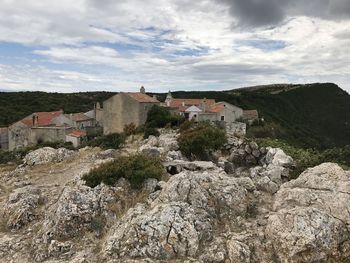 Buildings by mountain against sky