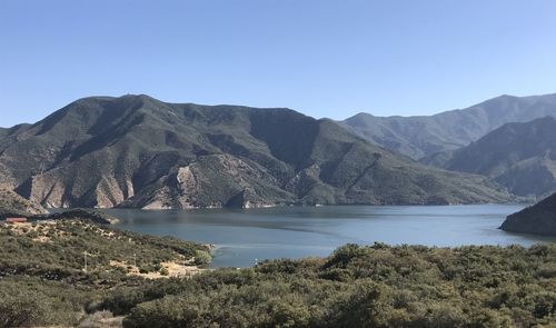 Scenic view of lake and mountains against clear sky