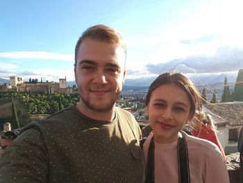 Portrait of smiling young woman against sky