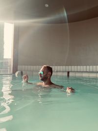 Portrait of shirtless man swimming in pool