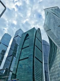 Low angle view of modern glass building against sky