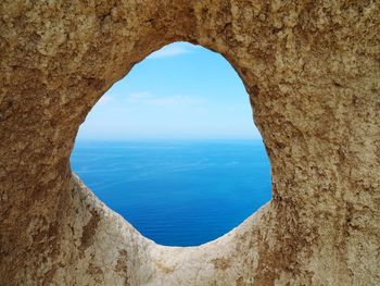 Scenic view of sea against sky seen through arch