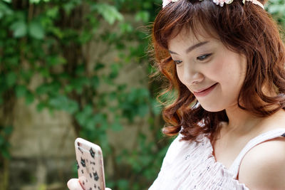 Smiling young woman using smart phone