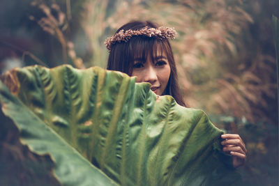 Portrait of young woman with plants