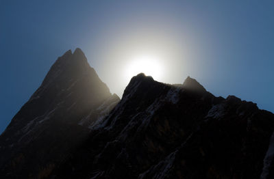 Low angle view of rocky mountains against clear sky