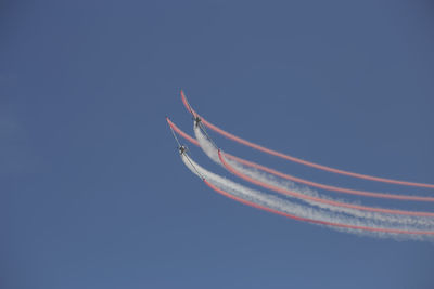 Low angle view of airplane flying against clear blue sky