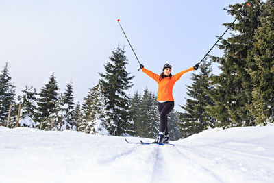 Full length of woman skiing on snow covered mountain